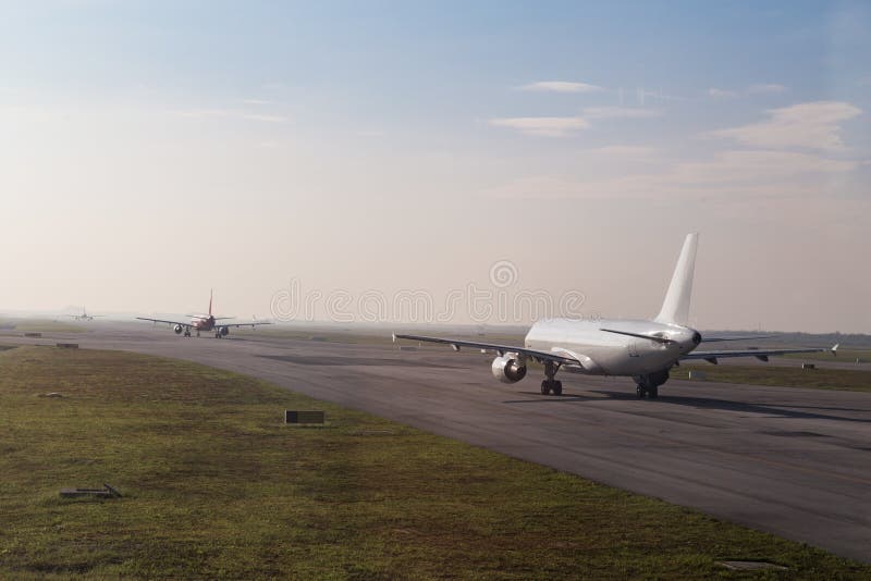 Fila comercial do avião que taxiing para decolar na pista de decolagem fotos de stock royalty free Fila comercial do avião que taxiing para decolar na pista de decolagem fotos de stock royalty free
