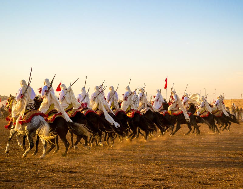 Photo taken in Morocco. Fantasia is a traditional exhibition of horsemanship in the Maghreb performed during cultural festivals and to close Berber wedding celebrations. Fantasia is an imported name, the actual traditional term used is lab el baroud (the gunpowder play). The performance consists of a group of horse riders, all wearing traditional clothes, who charge along a straight path at the same speed so as to form a line, and then at the end of the charge (about two hundred meters) fire into the sky using old muskets or muzzle-loading rifles. The difficulty of the performance is in synchronizing the movement of the horses during acceleration of the charge, and especially in firing the guns simultaneously so that one single shot is heard. The horse is referred to as a fantasia horse and is of the type called a Barb or Berber horse. Photo taken in Morocco. Fantasia is a traditional exhibition of horsemanship in the Maghreb performed during cultural festivals and to close Berber wedding celebrations. Fantasia is an imported name, the actual traditional term used is lab el baroud (the gunpowder play). The performance consists of a group of horse riders, all wearing traditional clothes, who charge along a straight path at the same speed so as to form a line, and then at the end of the charge (about two hundred meters) fire into the sky using old muskets or muzzle-loading rifles. The difficulty of the performance is in synchronizing the movement of the horses during acceleration of the charge, and especially in firing the guns simultaneously so that one single shot is heard. The horse is referred to as a fantasia horse and is of the type called a Barb or Berber horse.