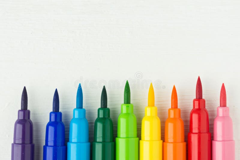 Fila dei pennelli multicolori della tavolozza dell'arcobaleno su fondo di legno bianco Hobby di creatività di arti che dipingono
