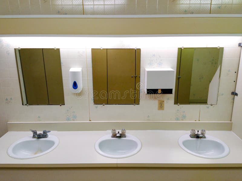 Fila pubblica leggermente grungy della toilette dei lavandini immagine stock Fila pubblica leggermente grungy della toilette dei lavandini immagine stock