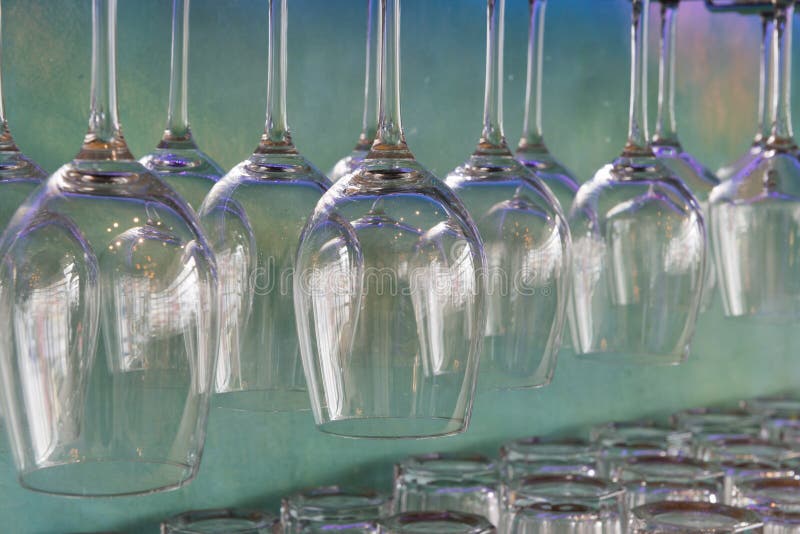 Filas de las copas de vino limpias que cuelgan en el estante imagenes de archivo