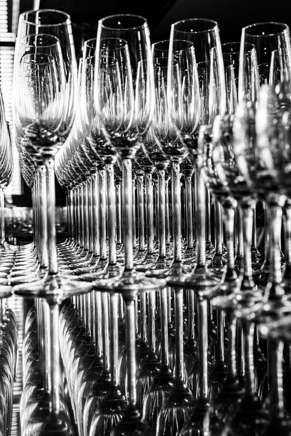 File di bicchieri di champagne vuoti, bianchi e neri fotografia stock