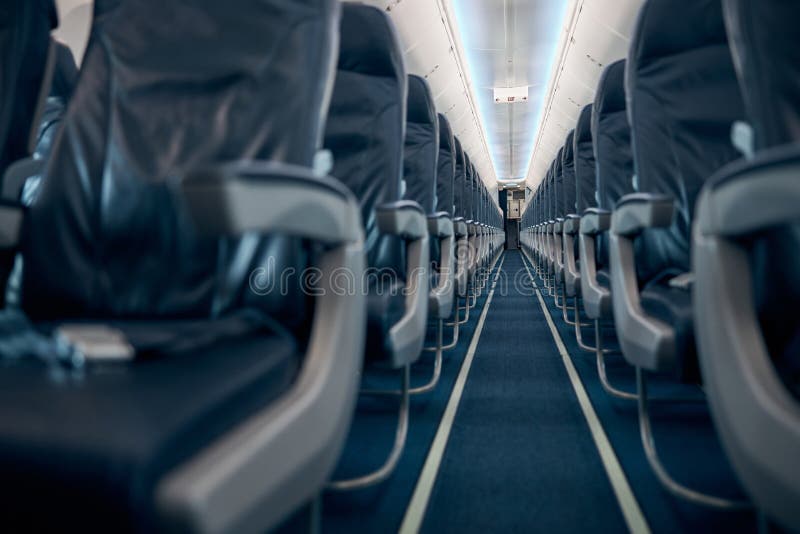 Low angle view of empty chairs in economy class aircraft of civil aviation. Low angle view of empty chairs in economy class aircraft of civil aviation