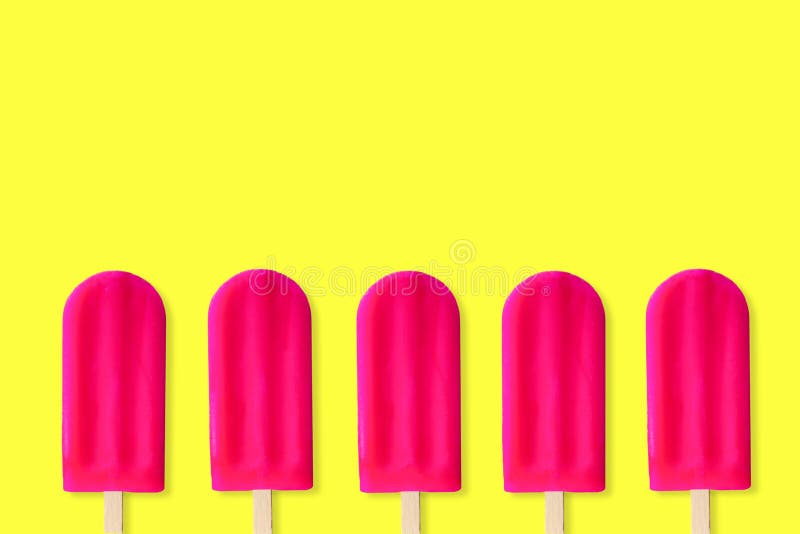 Fileira de picolés cor-de-rosa em um fundo amarelo foto de stock Fileira de picolés cor-de-rosa em um fundo amarelo foto de stock