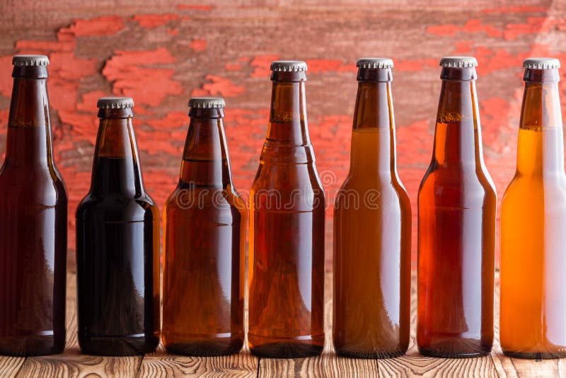 Fileira de sete tipos de cerveja em umas garrafas diferentes imagem de stock Fileira de sete tipos de cerveja em umas garrafas diferentes imagem de stock