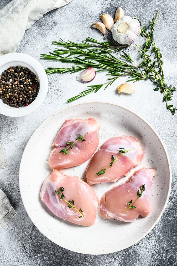 Raw chicken thigh fillet. Gray background. Top view. Raw chicken thigh fillet. Gray background. Top view.