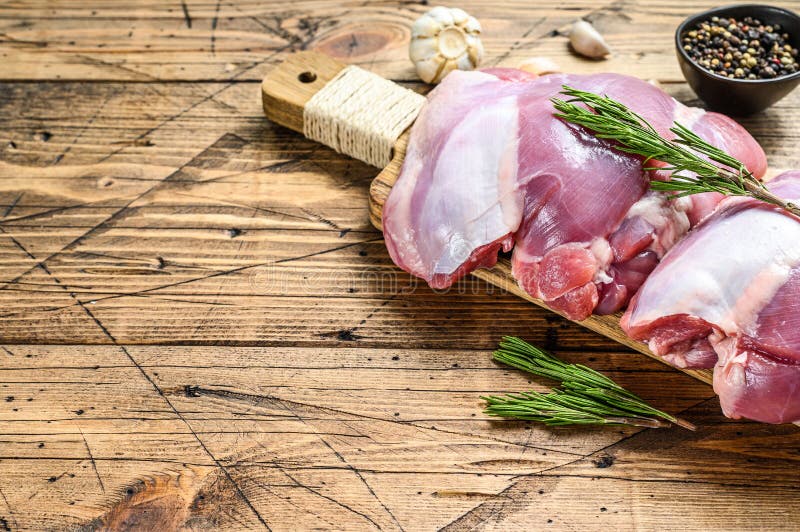 Raw Turkey thigh fillet with spices for cooking. Wooden background. Top view. Copy space. Raw Turkey thigh fillet with spices for cooking. Wooden background. Top view. Copy space.
