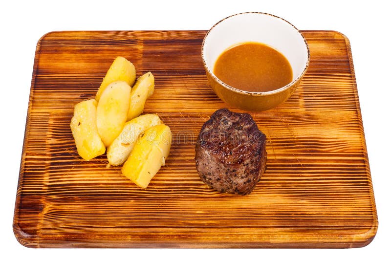 Filet Mignon mit Kartoffelkeilen auf isoliertem Holzbrett lizenzfreie stockfotos Filet Mignon mit Kartoffelkeilen auf isoliertem Holzbrett lizenzfreie stockfotos