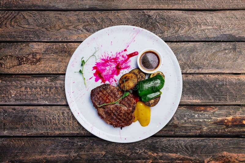 Filete de carne de vaca asado a la parrilla en una placa blanca con las verduras asadas a la parrilla imágenes de archivo libres de regalías Filete de carne de vaca asado a la parrilla en una placa blanca con las verduras asadas a la parrilla imágenes de archivo libres de regalías