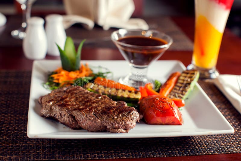 Filete de carne de vaca con las verduras asadas a la parrilla servidas en la placa blanca Concepto del alimento foto de archivo Filete de carne de vaca con las verduras asadas a la parrilla servidas en la placa blanca Concepto del alimento foto de archivo