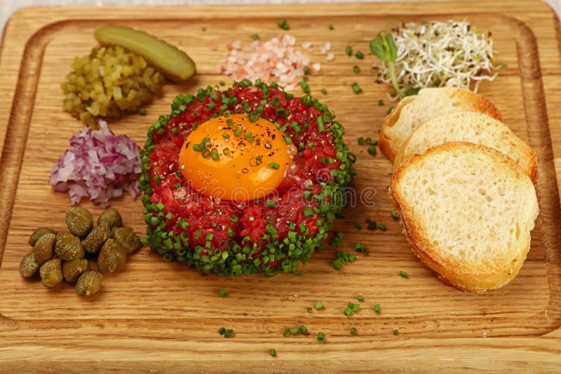 Filete tartare de la carne cruda con cierre de la yema de huevo para arriba imagen de archivo