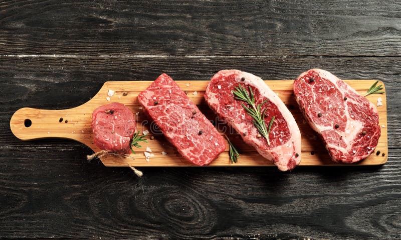 Filetes de carne de vaca negros primeros crudos frescos de Angus en el tablero de madera foto de archivo libre de regalías