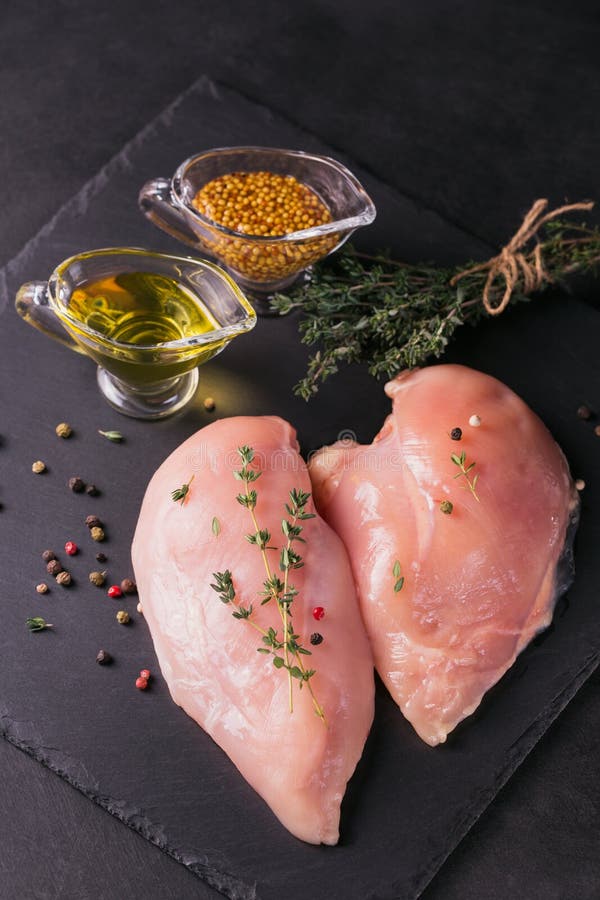 Filets crus de poulet avec des épices et des herbes photographie stock libre de droits Filets crus de poulet avec des épices et des herbes photographie stock libre de droits