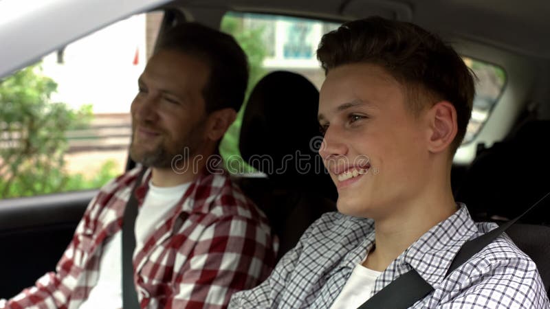 Son with father testing new bought car, dad teaching teen boy to drive auto, stock photo. Son with father testing new bought car, dad teaching teen boy to drive auto, stock photo