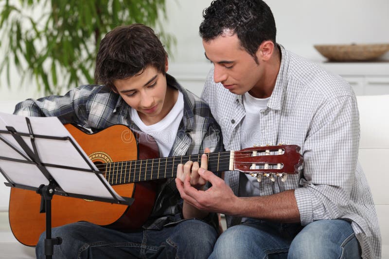 Filho de ensino do pai a guitarra fotos de stock Filho de ensino do pai a guitarra fotos de stock