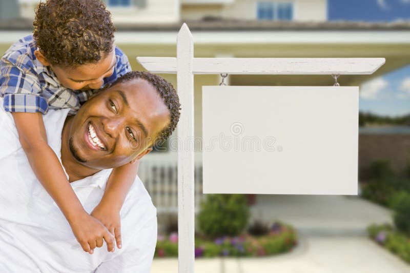 Happy African American Father and Mixed Race Son In Front of Blank Real Estate Sign and New House. Happy African American Father and Mixed Race Son In Front of Blank Real Estate Sign and New House.
