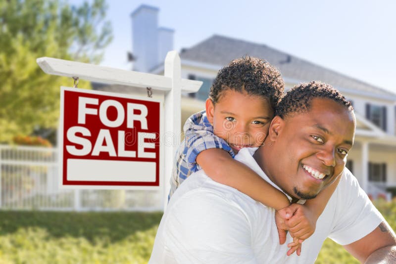 African American Father and Mixed Race Son In Front of Home For Sale Real Estate Sign and New House. African American Father and Mixed Race Son In Front of Home For Sale Real Estate Sign and New House.