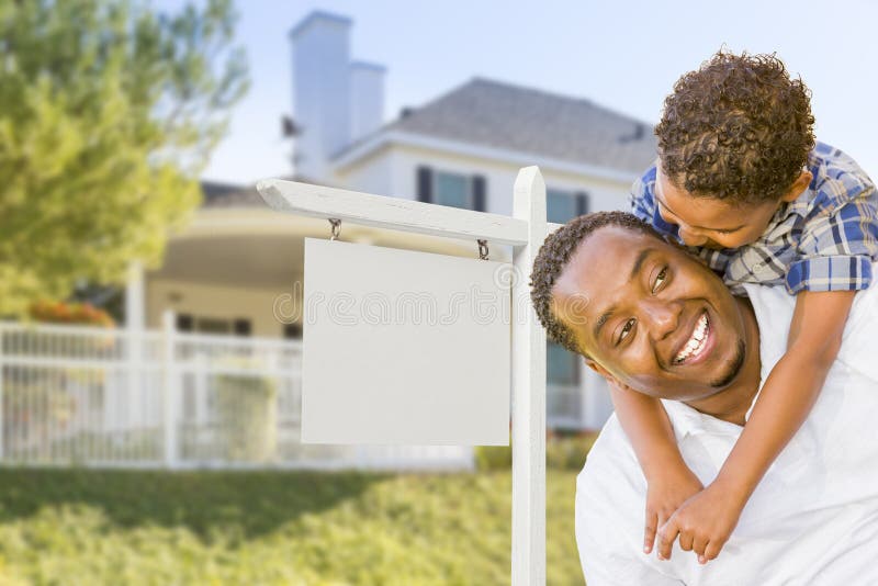 Happy African American Father and Mixed Race Son In Front of Blank Real Estate Sign and New House. Happy African American Father and Mixed Race Son In Front of Blank Real Estate Sign and New House.