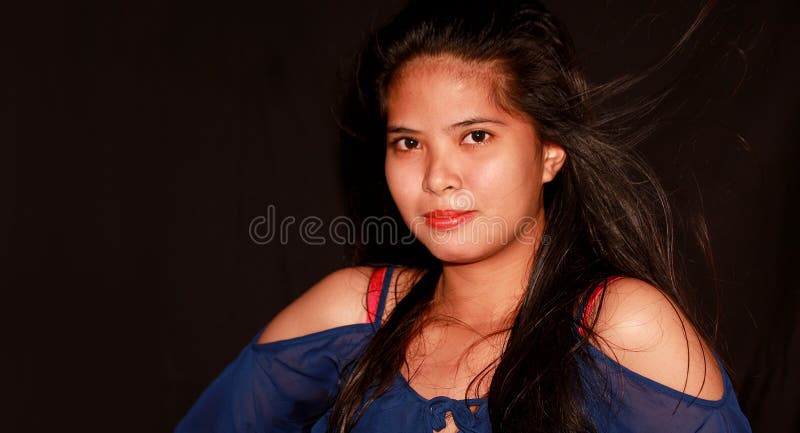 Filipina bastante joven que mira a través de la cámara imagen de archivo libre de regalías Filipina bastante joven que mira a través de la cámara imagen de archivo libre de regalías