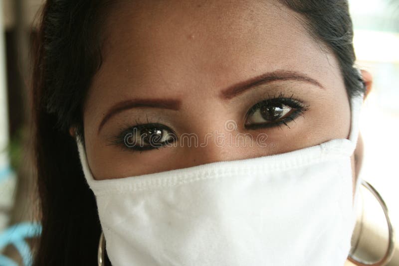 A filipina wearing a surgical mask to prevent the bird flu. A filipina wearing a surgical mask to prevent the bird flu