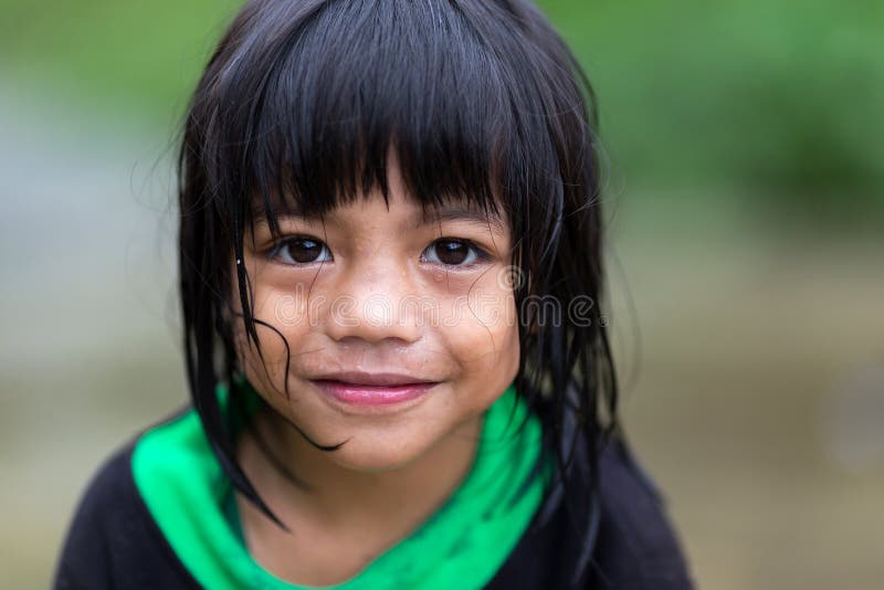 A young unidentified Filipino little girl is standing under the rain in the village of Banaue, north Luzon, Philippines, on december 04, 2013. A young unidentified Filipino little girl is standing under the rain in the village of Banaue, north Luzon, Philippines, on december 04, 2013