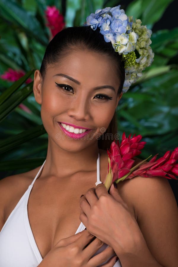 Pretty Filipina with red ginger flower looking at the camera