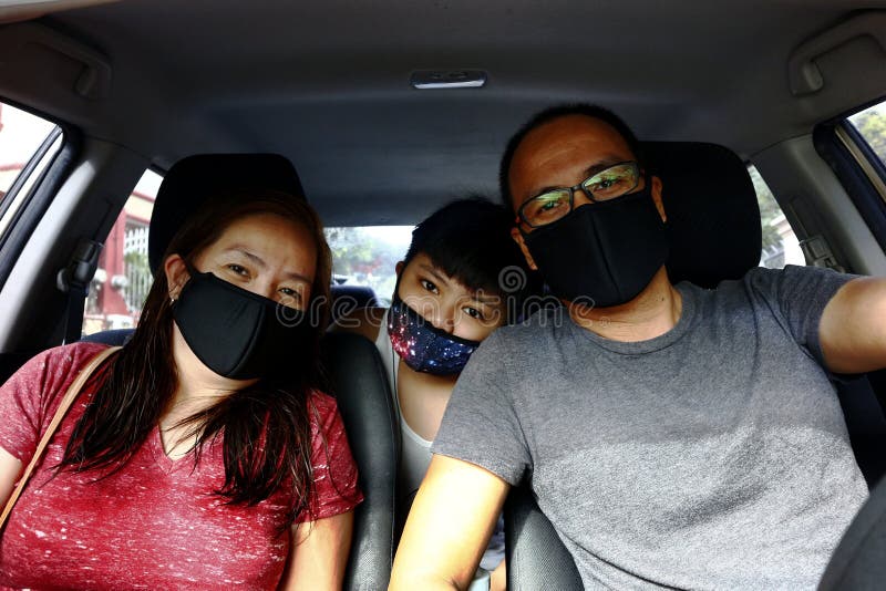 Portrait of a Filipino family with face mask on while inside a car