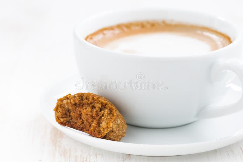 Filiżanka cappuccino i migdałowy ciastko, selekcyjna ostrość zdjęcie royalty free Filiżanka cappuccino i migdałowy ciastko, selekcyjna ostrość zdjęcie royalty free