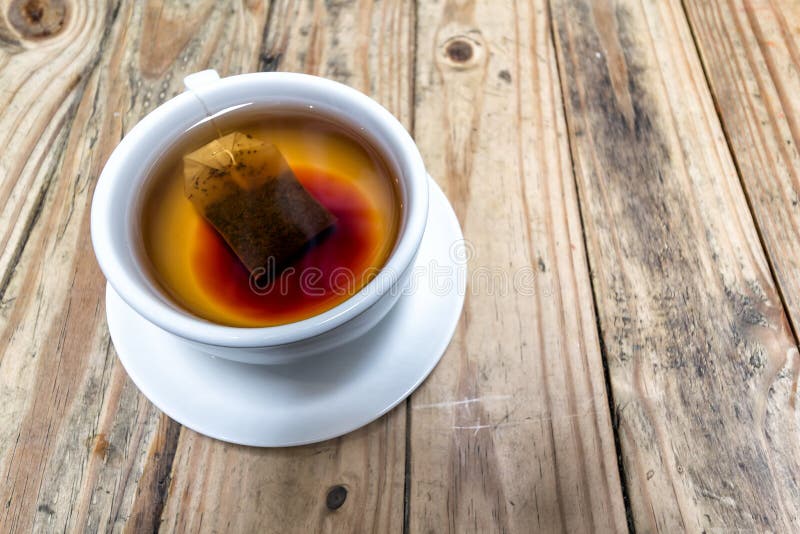 Cup of Hot Tea with Teabag on Grunge Wood Table Background. Cup of Hot Tea with Teabag on Grunge Wood Table Background