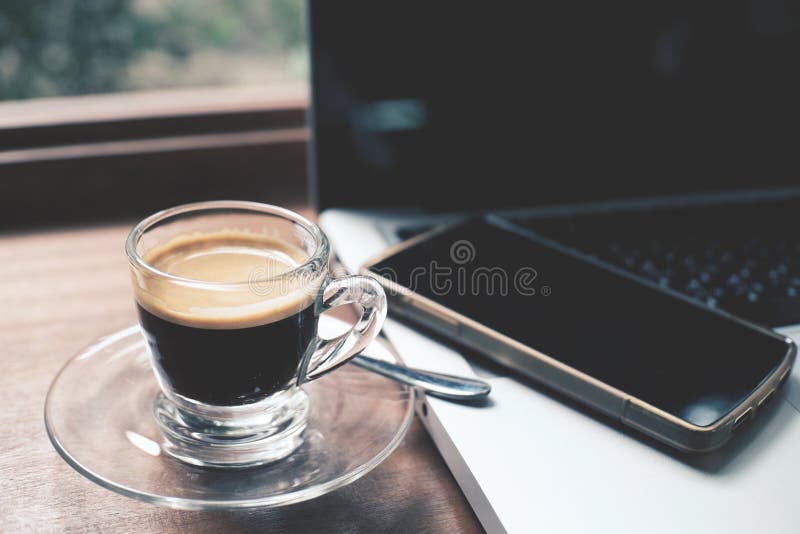 Filiżanka gorąca kawy espresso kawa z laptopem i smartphone fotografia stock Filiżanka gorąca kawy espresso kawa z laptopem i smartphone fotografia stock