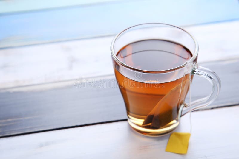 Cup of tea with teabag on wooden table. Cup of tea with teabag on wooden table