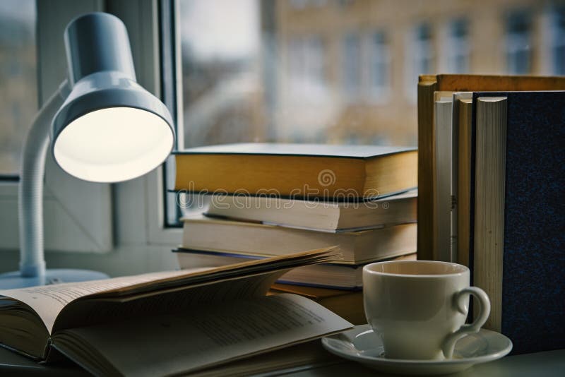 Filiżanka herbata, otwiera książkę pod lampą zdjęcie stock Filiżanka herbata, otwiera książkę pod lampą zdjęcie stock