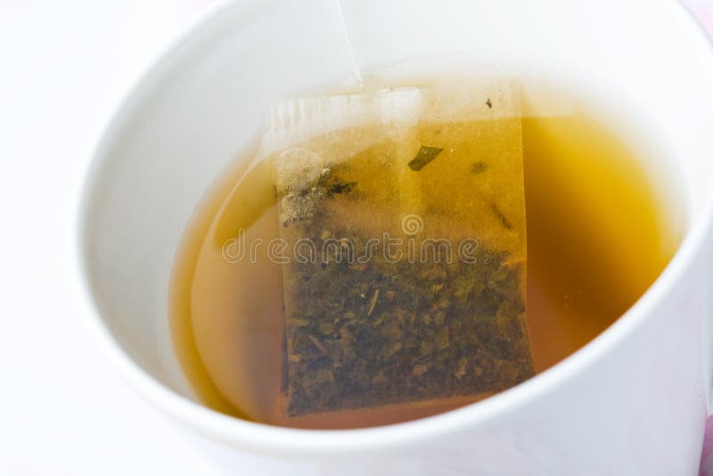 A cup of green tea with a teabag. A cup of green tea with a teabag