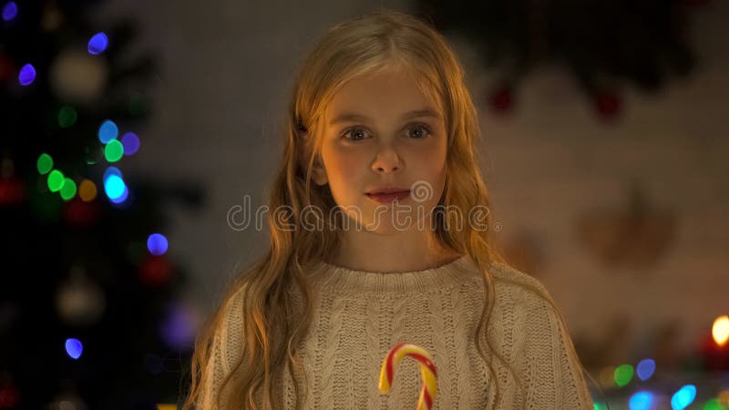 Fille adorable avec la sucrerie regardant la caméra, miracle de attente de Santa Christmas images libres de droits Fille adorable avec la sucrerie regardant la caméra, miracle de attente de Santa Christmas images libres de droits