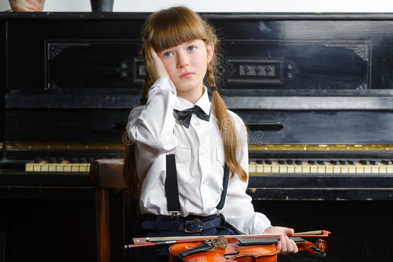 Fille affolée ou affligée saisissant sa tête et tenant un violon images stock Fille affolée ou affligée saisissant sa tête et tenant un violon images stock