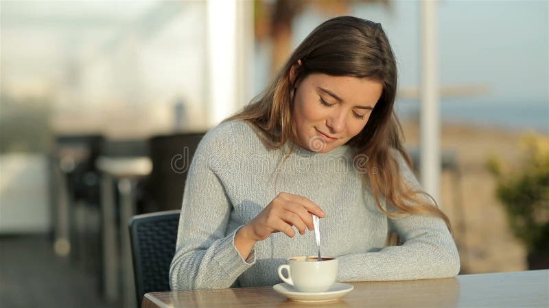 Fille agitant le café assis dans un restaurant au ralenti