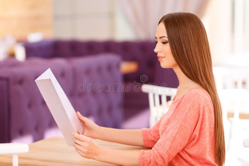 Fille agréable tenant le menu photo stock