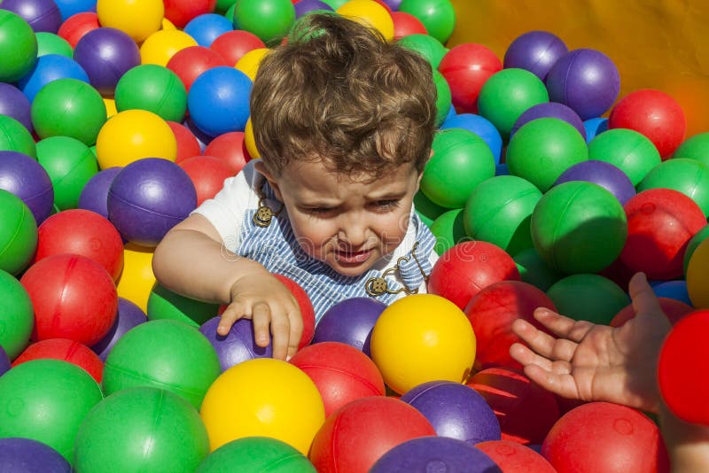 Fille aidant son petit frère sortant une piscine de boule image stock Fille aidant son petit frère sortant une piscine de boule image stock