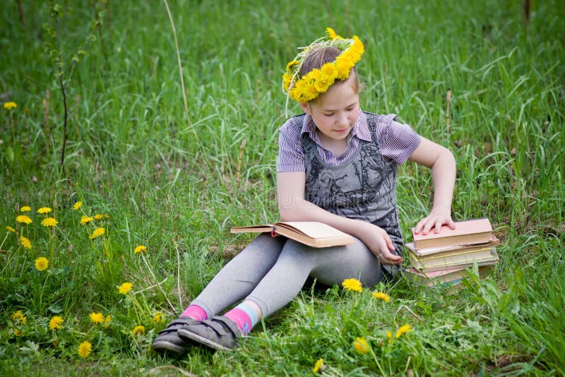 Fille apprenant dans le pré photos libres de droits Fille apprenant dans le pré photos libres de droits