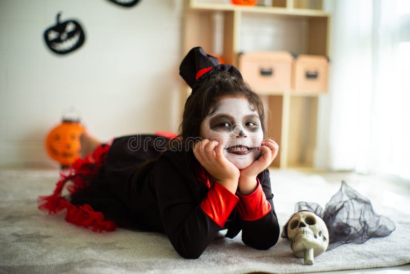 Fille asiatique de portrait petite dans le costume de Halloween souriant au c photo libre de droits Fille asiatique de portrait petite dans le costume de Halloween souriant au c photo libre de droits