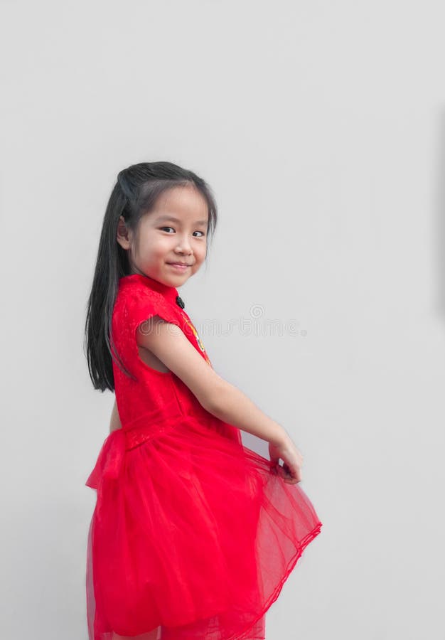 Fille asiatique mignonne dans le cheongsam chinois et robe chinoise de tradition avec l'enveloppe rouge, concept chinois de nouve photographie stock libre de droits Fille asiatique mignonne dans le cheongsam chinois et robe chinoise de tradition avec l'enveloppe rouge, concept chinois de nouve photographie stock libre de droits