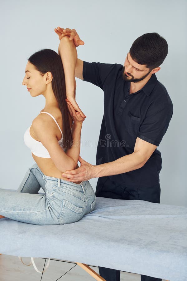 Fille assise. physiothérapeute travaille avec une jeune femme à l'intérieur du spa photographie stock
