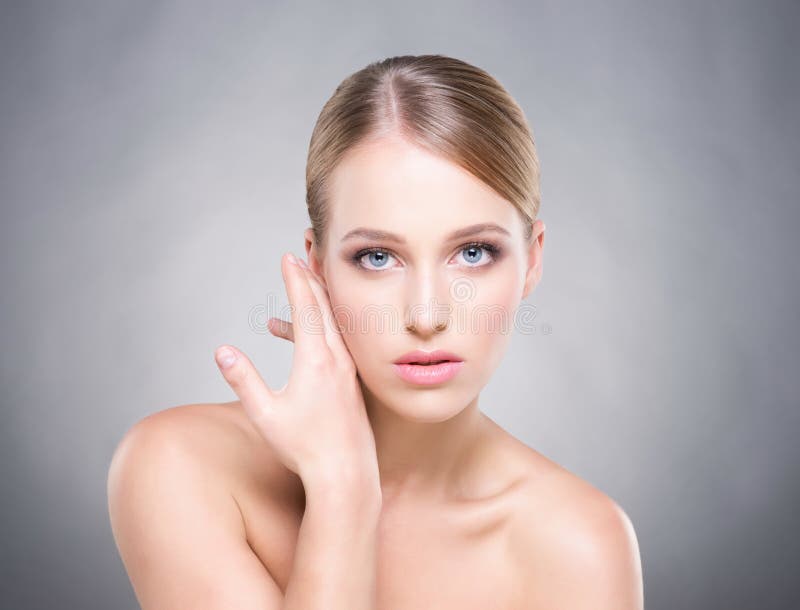 Fille attirante avec la peau lisse au-dessus du fond gris images stock Fille attirante avec la peau lisse au-dessus du fond gris images stock