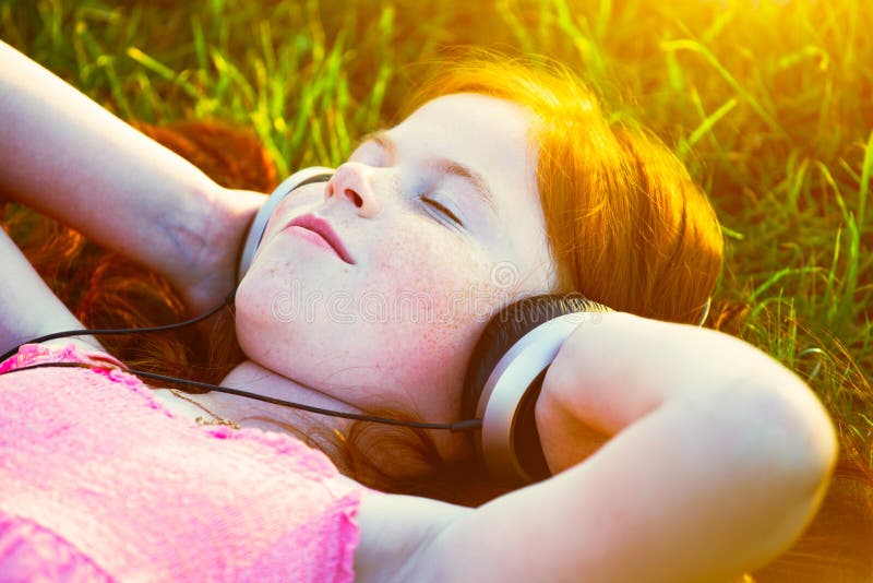 Fille avec des écouteurs écoutant la musique. Fille rousse avec des écouteurs écoutant rêver de musique