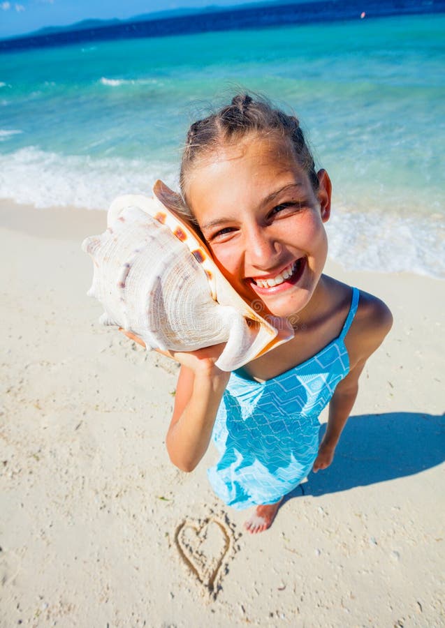 Fille avec la coquille à la plage images stock Fille avec la coquille à la plage images stock