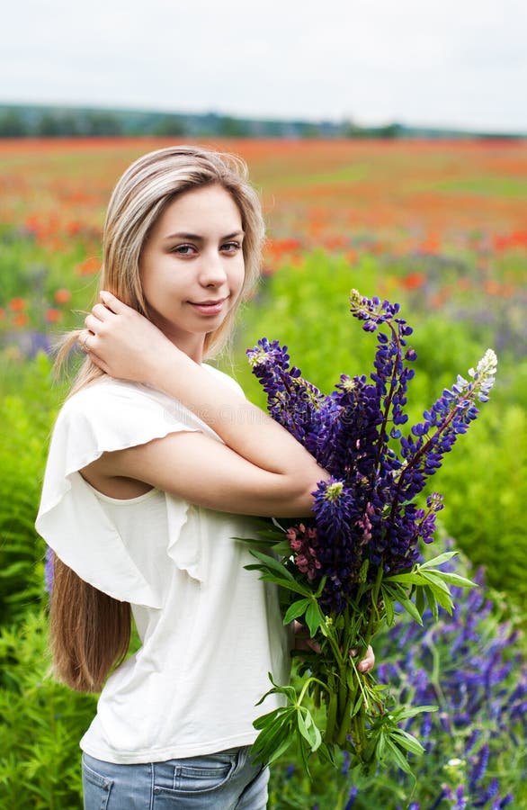 Fille avec le bouquet des fleurs de loup photos stock Fille avec le bouquet des fleurs de loup photos stock