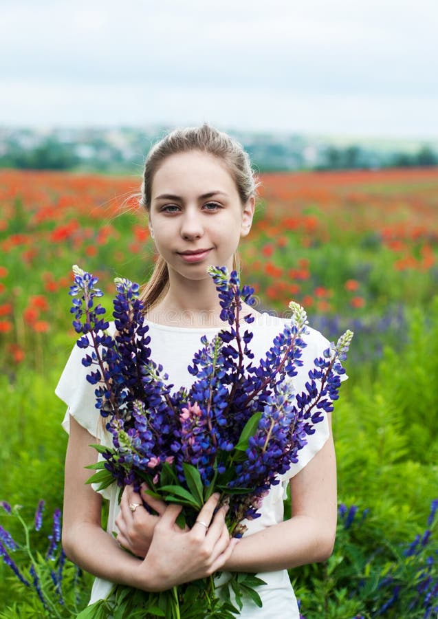 Fille avec le bouquet des fleurs de loup photographie stock Fille avec le bouquet des fleurs de loup photographie stock