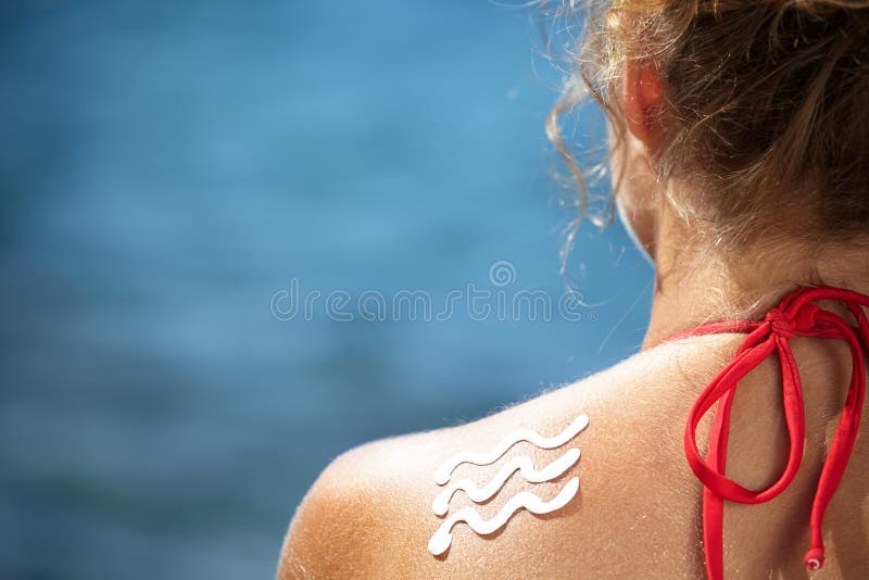 Fille avec le coup de soleil et la vague de la lotion du soleil images stock Fille avec le coup de soleil et la vague de la lotion du soleil images stock