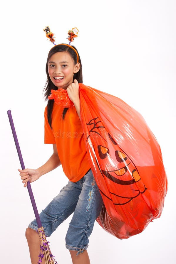 A young girl carrying a big pumpkin halloween bag. A young girl carrying a big pumpkin halloween bag