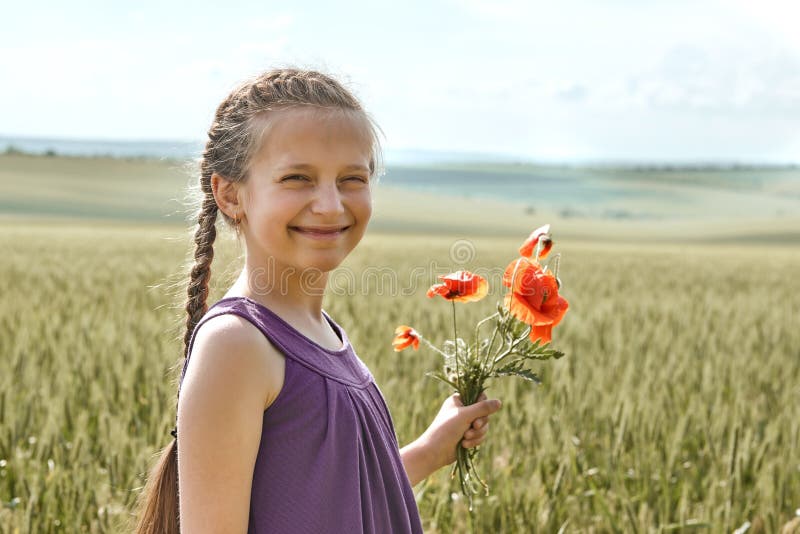 Fille avec les fleurs rouges de tulipe posant dans le domaine de blé, le soleil lumineux, beau paysage d'été images libres de droits Fille avec les fleurs rouges de tulipe posant dans le domaine de blé, le soleil lumineux, beau paysage d'été images libres de droits
